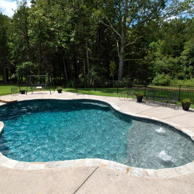 freeform pool in fenced garden