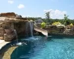 Thumnbail of stone wall and slide into swimming pool
