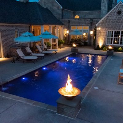 luxury pool with fire features at night